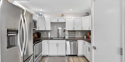Contemporary kitchen in Scottsdale with stainless appliances, white cabinets, and tile backsplash offering both style and functionality.