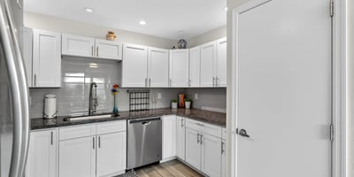 Stylish Scottsdale kitchen featuring white cabinetry, tile backsplash, and functional layout designed for efficient meal prep and storage.