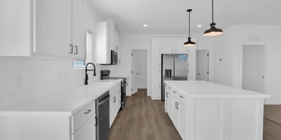 Modern kitchen showcasing an oversized island, stainless steel appliances, shaker cabinetry, and extensive workspace. Ideal for meal preparation, entertaining, and enjoying the heart of this beautifully designed home.