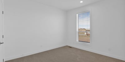 Comfortable bedroom with soft carpeting, neutral d cor, and a large picture window. This flexible room is ideal for guests, family members, or a dedicated office setup.