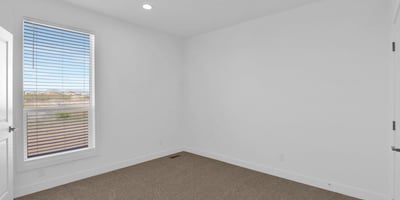 Light-filled bedroom with attractive finishes, large windows, and comfortable carpeting. Perfect for use as a guest room, family bedroom, hobby room, or home office.