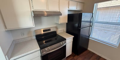 Kitchen highlights include updated black appliances, bright cabinetry, and easy-care countertops. The practical layout offers excellent workspace and storage for comfortable apartment living.