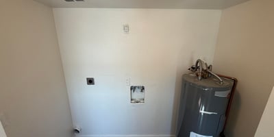 Interior utility room with washer and dryer hookups, dedicated laundry connections, and water heater access. This practical feature adds convenience and supports an efficient lifestyle.