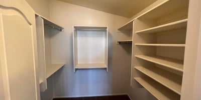 Large walk-in closet complete with built-in shelving and multiple hanging sections. Ideal for keeping clothing, shoes, and accessories neatly organized and easily accessible.