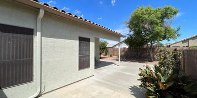 Large patio area overlooking the landscaped backyard with mature trees and low-maintenance grounds. This outdoor living space offers the perfect setting for dining, entertaining, and enjoying the Arizona lifestyle in a desirable Goodyear location.