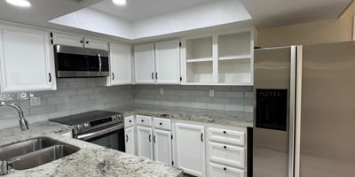 Updated kitchen featuring granite countertops, stainless steel appliances, refreshed cabinetry, and a modern tile backsplash. Designed to combine style, storage, and functionality.