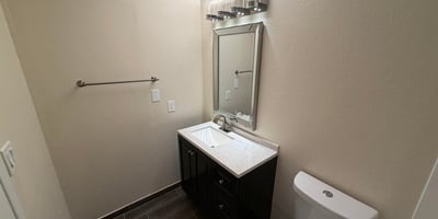 Well-maintained guest bathroom featuring a refreshed vanity, upgraded lighting, stylish mirror, and modern finishes. Thoughtful updates create a welcoming space that blends style and practicality.