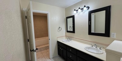 Well-appointed bathroom showcasing a double vanity, updated fixtures, abundant counter space, and tile flooring. Designed for everyday convenience, this space supports busy households and visiting guests alike.
