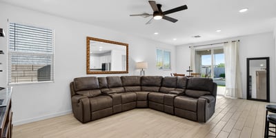The expansive great room offers an open layout with durable wood-look flooring, recessed lighting, ceiling fan, and flexible space for relaxing, entertaining, and everyday living.