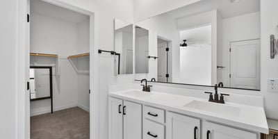 Enjoy added convenience with a spacious dual-sink vanity, modern cabinetry, quartz countertops, and direct access to the large walk-in closet in this thoughtfully designed ensuite.