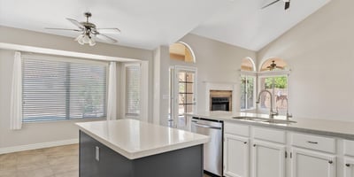 The updated kitchen features a large center island, stainless steel appliances, newer finishes, and an open layout overlooking the family room with backyard access. A perfect design for entertaining and everyday living.