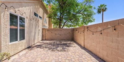 The spacious paver patio offers additional outdoor living space ideal for grilling, outdoor dining, or creating a peaceful sitting area. Mature landscaping adds shade and privacy to this Chandler backyard.
