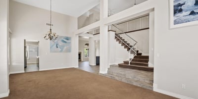 Enjoy an expansive open living space featuring soaring ceilings, a dramatic staircase, and abundant natural light. The thoughtful layout creates an inviting atmosphere that flows effortlessly into the adjoining living areas, making it ideal for entertaining or relaxing.
