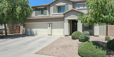 Well-maintained front exterior highlighting mature landscaping, covered entrance, and a spacious 3-car garage. This beautiful Waddell home offers lasting curb appeal.