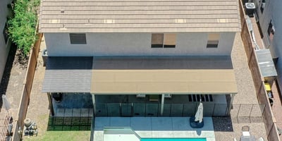 Incredible aerial perspective highlighting the sparkling pool, covered patio, custom pergola, grassy yard, and thoughtfully designed outdoor living spaces that make this Waddell home truly exceptional.