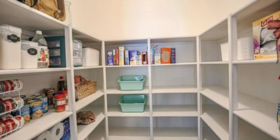 Oversized walk-in pantry with extensive built-in shelving and abundant storage, providing excellent organization for food, cookware, and household essentials just steps from the updated kitchen.