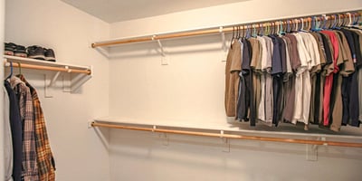 Generous walk-in closet with multiple clothing rods and abundant storage capacity, creating an organized and functional extension of the spacious primary suite.