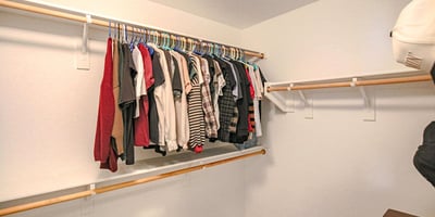 Spacious secondary walk-in closet featuring ample hanging space and flexible storage options, offering exceptional organization within the primary suite of this Waddell home.