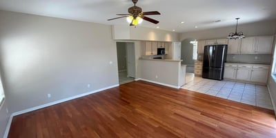 Rich wood flooring, recessed lighting, and an open floor plan make this inviting great room perfect for entertaining, family gatherings, or relaxing at home.