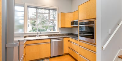 Bright and modern kitchen featuring ample storage, sleek appliances, and a view of the landscaped garden.