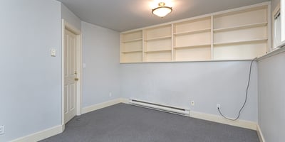 Spacious room featuring built-in shelves and neutral tones, perfect for a home office or study.