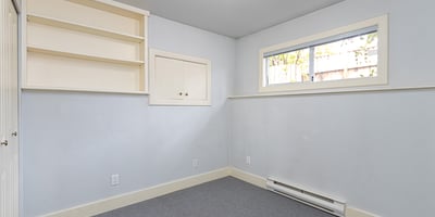 Bright, versatile room with built-in shelving, offering potential for a home office or creative space.