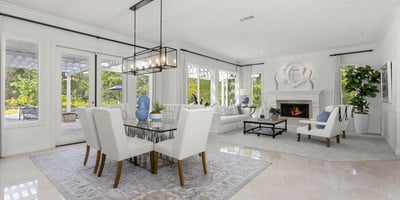 Bright and spacious living area with large windows, a cozy fireplace, and a seamless outdoor connection.