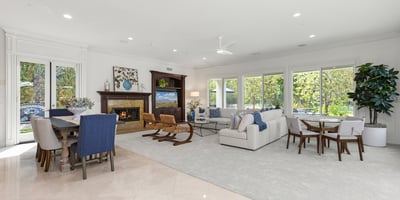 flooded with abundant natural light, showcasing a cozy fireplace and open connectivity to dining spaces.