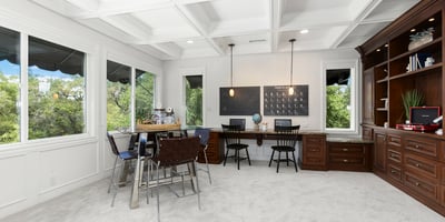 Loft/Entertaining Space featuring large windows, custom cabinetry, and versatile workspace for productivity.