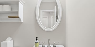 Bright, well-maintained bathroom featuring modern fixtures and a circular mirror, perfect for everyday use.