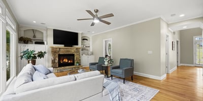 Spacious living area featuring a cozy fireplace, large windows, and modern finishes, ideal for gathering.