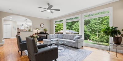 Spacious living room with expansive windows offering ample natural light and a picturesque view of the backyard.