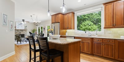 Bright and functional kitchen featuring wooden cabinetry, granite countertops, and a spacious island perfect for gatherings.