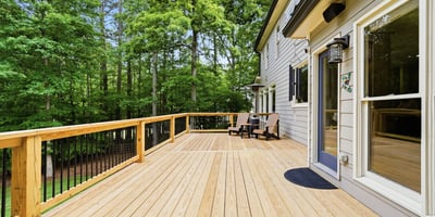 Spacious deck surrounded by lush greenery, perfect for outdoor gatherings and enjoying nature.
