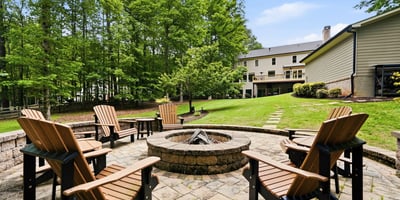 Gather around the fire pit in this spacious backyard, nestled among lush greenery and nature.