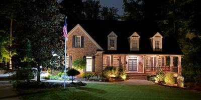 This beautifully illuminated home features inviting landscaping and ample outdoor space, perfect for evening gatherings.