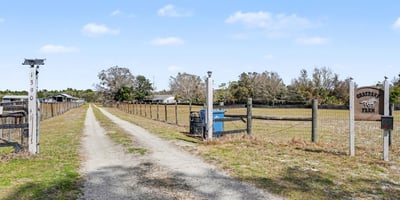 A view of the private driveway from East Ohio Avenue facing north. East Ohio Avenue is a public, county maintained, paved road which easily accommodates trailers, utility vehicles, etc. Bring those toys! Bring those animals! No HOA and county taxes (not city).