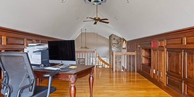 Spacious loft office features rich wood accents and ample natural light, perfect for productivity and creativity.
