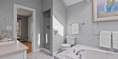 Bright and inviting bathroom featuring a soaking tub, walk-in shower, and modern finishes throughout.