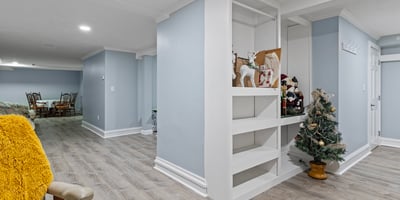 Bright and spacious basement with versatile layout, featuring built-in shelving and ample room for activities.