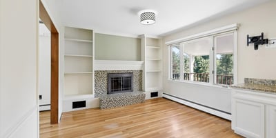 Spacious living area with a fireplace, featuring large windows that invite abundant natural light.
