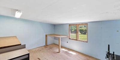 Spacious room with ample natural light, featuring a convenient workspace and easy access to the outdoors.