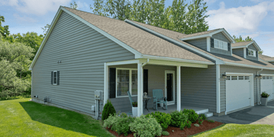 Welcoming home featuring a spacious front yard, ample natural light, and convenient parking.
