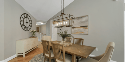 Bright dining area featuring vaulted ceilings, contemporary lighting, and a warm wood table, perfect for gatherings.