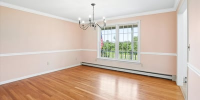 Spacious room with abundant natural light, featuring hardwood floors and a picturesque view. Perfect for customization.