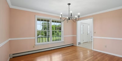Bright, well-lit dining area featuring expansive windows, hardwood floors, and unique chandelier accents.