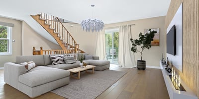 Bright and spacious living area features a unique design, natural light, and direct access to the outdoor space.