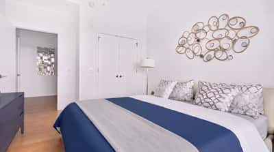 Bright bedroom featuring modern decor, plush bedding, and a unique wall art element for added character.
