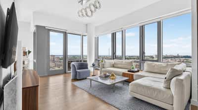 Bright and airy living space with expansive windows offering stunning city views and modern design touches.