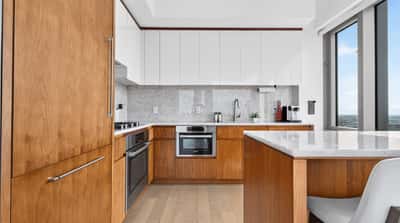 Modern kitchen featuring sleek cabinetry and expansive windows, creating a bright and inviting cooking space.